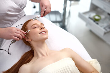 Obraz na płótnie Canvas closeup photo of girl having face polishing procedure by professional therapist in beauty salon
