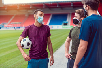 Soccer players in football stadium during covid-19 wearing masks