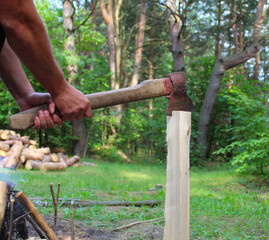 chopping wood, with an ax in the hands of men, against the background of a fire and a forest
