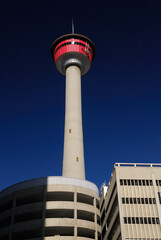 Fototapeta na wymiar Calgary Tower against a deep blue sky with concrete garage