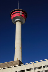 Calgary Tower against a deep blue sky with concrete building