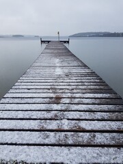 pier on the lake with snow