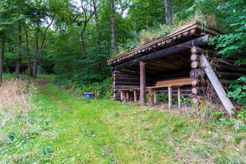 Old wooden shelter in the forest.