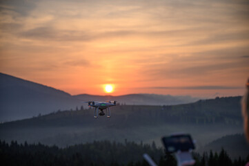 Silhouette Drone flying on mountain sunrise sky with cloud, Aerial photography. mountains landscape with sun and alpine pines. Sunrise
