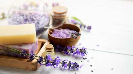 Lavender soap and Spa products with lavender flowers on a white table.