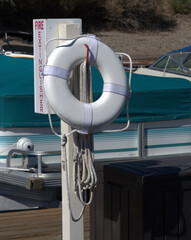 Small life preserver on a boat dock with fire extinguisher  marker.