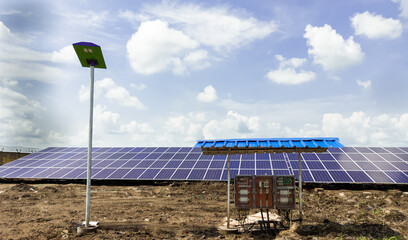 Row of installed Photovoltaic solar panels or modules, solar street light and string combiner box, string monitoring box with weather protective canopy.