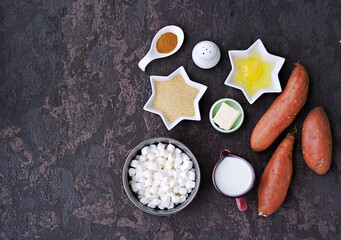 Ingredients for cooking sweet potato casseroles with marshmallows, a traditional Thanksgiving dessert on brown concrete background. American cuisine. Sweet potato recipes.
