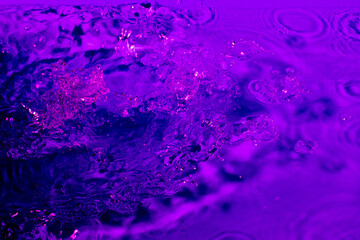 splash of water in lilac light. Abstract wallpaper