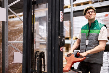 Fototapeta na wymiar young caucasian warehouse worker with hand pallet truck with package shipment sending to customers, in store