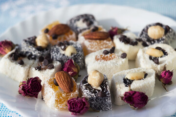 Assorted Turkish delight on a white plate, Turkish multicolored sweets with nuts. Goodies
