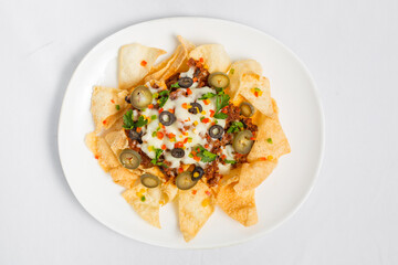 Mexican Famous Food Spicy Ground Beef Nachos. Heated crunchy tortilla chips with melted cheese and jalapeno served a snack food.