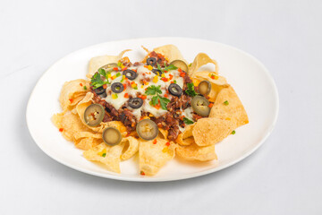 Mexican Famous Food Spicy Ground Beef Nachos. Heated crunchy tortilla chips with melted cheese and jalapeno served a snack food.