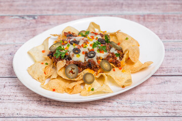 Mexican Famous Food Spicy Ground Beef Nachos. Heated crunchy tortilla chips with melted cheese and jalapeno served a snack food.