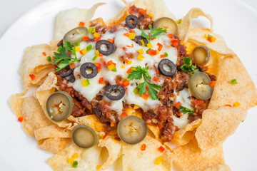 Mexican Famous Food Spicy Ground Beef Nachos. Heated crunchy tortilla chips with melted cheese and jalapeno served a snack food.