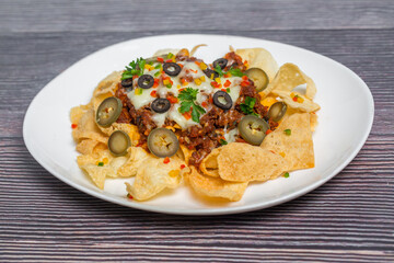 Mexican Famous Food Spicy Ground Beef Nachos. Heated crunchy tortilla chips with melted cheese and jalapeno served a snack food.
