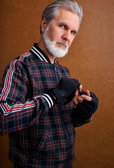 mature elderly man bandaging his hand before box training, senior caucasian man bandaging hands, injured hand and bandage it