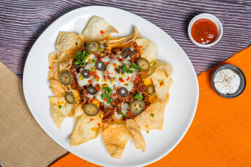 Mexican Famous Food Spicy Ground Beef Nachos. Heated crunchy tortilla chips with melted cheese and jalapeno served a snack food.