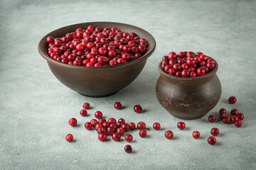 Lingonberries in earthenware on gray background