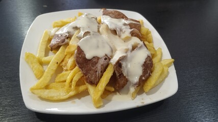 Filetes con patatas fritas y salsa de queso