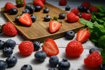 blueberries and strawberries on white background with mint sprigs