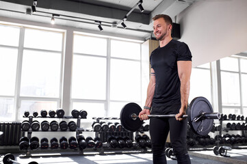 young caucasian man performing a deadlift. fit and focused young man straining to lift heavy...
