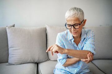 Elbow Pain In An Elderly Person. People, health care and problem concept - unhappy woman suffering....