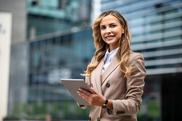 Blonde businesswoman using a digital tablet outdoor