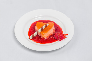 Heart-shaped pudding with strawberry sauce and wafer. Valentine's dessert recipe.