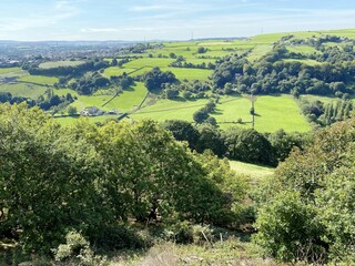 Fototapeta na wymiar Landscape from the hills, looking toward Halifax, with trees, fields, and meadows, on a hot sunny day in, Halifax, Yorkshire, UK