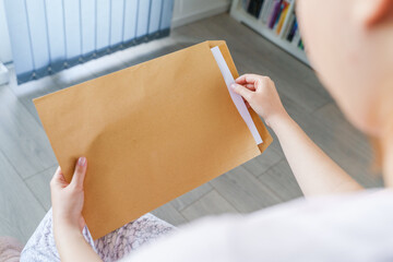 Close up on hands of unknown caucasian woman hold envelope opening or sending letter with mail or...
