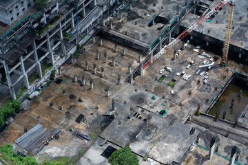 Top view of the construction site of a large building after rain. Piles are driven in and the lower floors are built.