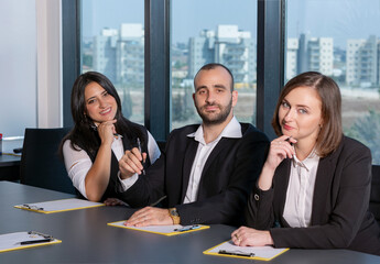 Business people during meeting in board room. Colleagues at business meeting in conference room. Always brainstorming. Smiling colleagues working together at desk in office discussing papers