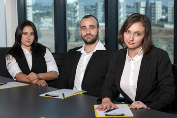 Business people during meeting in board room. Colleagues at business meeting in conference room. Always brainstorming. Smiling colleagues working together at desk in office discussing papers