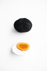 An old duck egg recipe in ash. Salty pickled duck egg in ash on a white background
