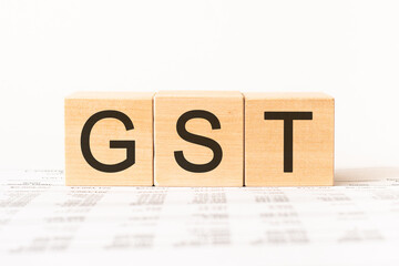 Word gst. Wooden small cubes with letters isolated on white background with copy space available.Business Concept image.