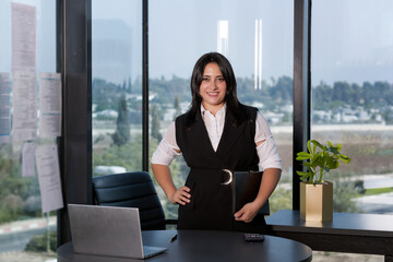 Portrait of beautiful young woman working in office looking and smiling at camera