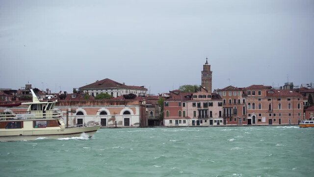 Tourist cruise boat in Grand Canal of Venezia.Rental ferryboat cruising on water in venetian canals.Popular attaction for tourists in Italian historic city