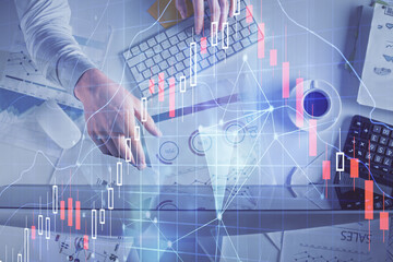 Multi exposure of man's hands typing over computer keyboard and forex graph hologram drawing. Top...