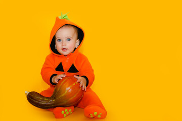 Child in pumpkin suit on yellow background with pumpkin