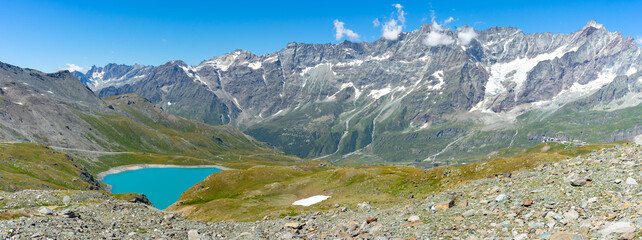 Plakat un lac bleu dans les alpages avec une chaine de montagne en fond 