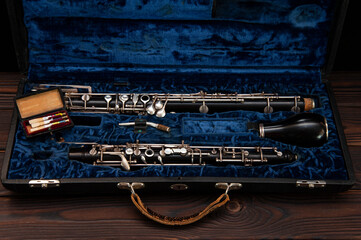 English horn or oboe in a case with reeds for playing on a wooden surface