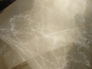 Organza in white and beige or champagne color close-up. Lightweight sheer tulle curtains under side...