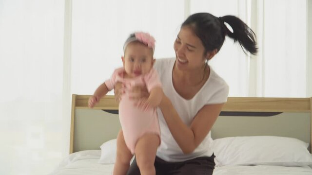 Young mother and daughter Baby playing in the bedroom