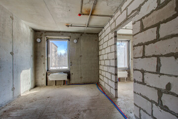 Unfinished construction empty room. Walls from lightweight aggregate concrete blocks with empty...