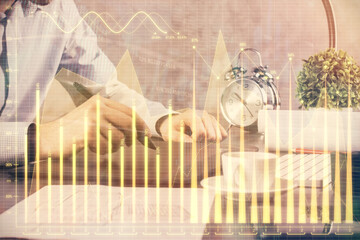 Double exposure of man's hands holding and using a phone and financial graph drawing. Analysis concept.