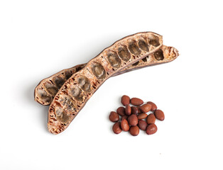 empty carob pods and poured seeds heap, top view, isolated on white background