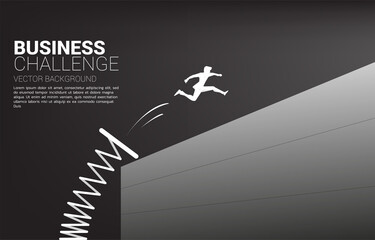 Silhouette of businessman jump across the wall with springboard. Concept of boost and move forward in business.