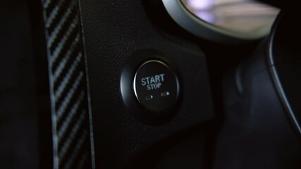 stopping the engine of a car.Finger press the button to stop the car engine with hand held.