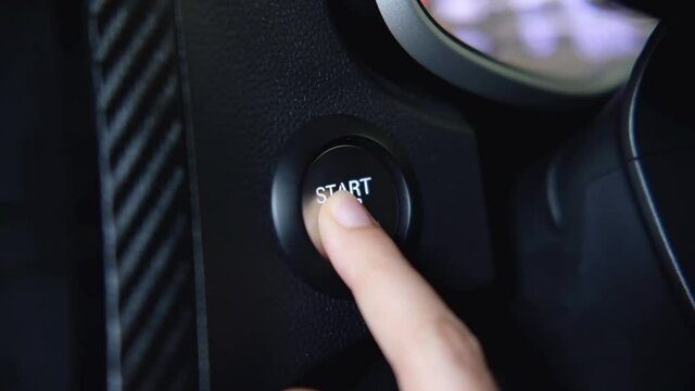 stopping the engine of a car.Finger press the button to stop the car engine with hand held.